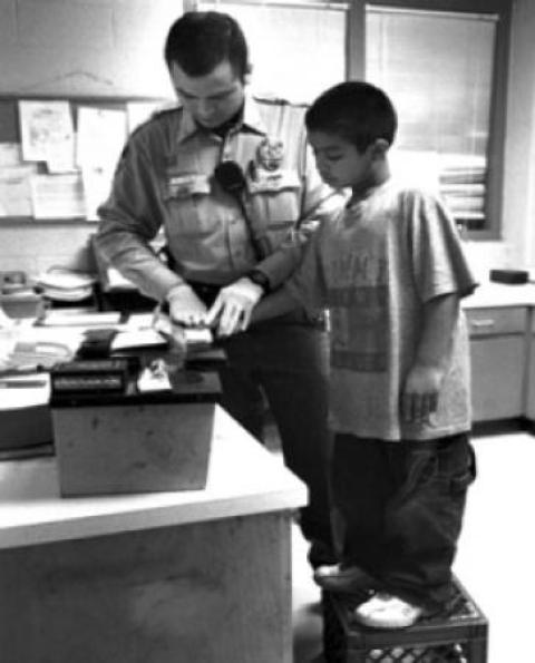 Officer finger printing kid