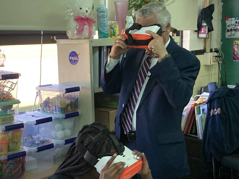 Rep. Robert C. Scott, D-Newport News, gets a peek at an erupting volcano in a virtual reality headset at Sedgefield Elementary School. (Dave Ress)